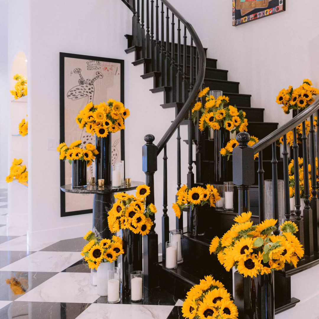 Luxury sunflower floral installations decorating a grand staircase for a private Las Vegas event designed by Miss Daisy Flowers.