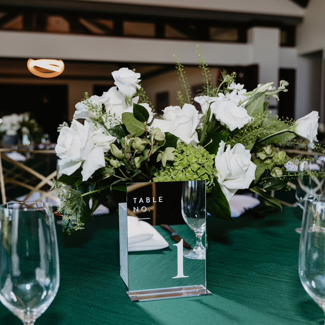 Elegant white floral centerpiece with roses and tulips by Miss Daisy Floral at the Las Vegas Museum of Art